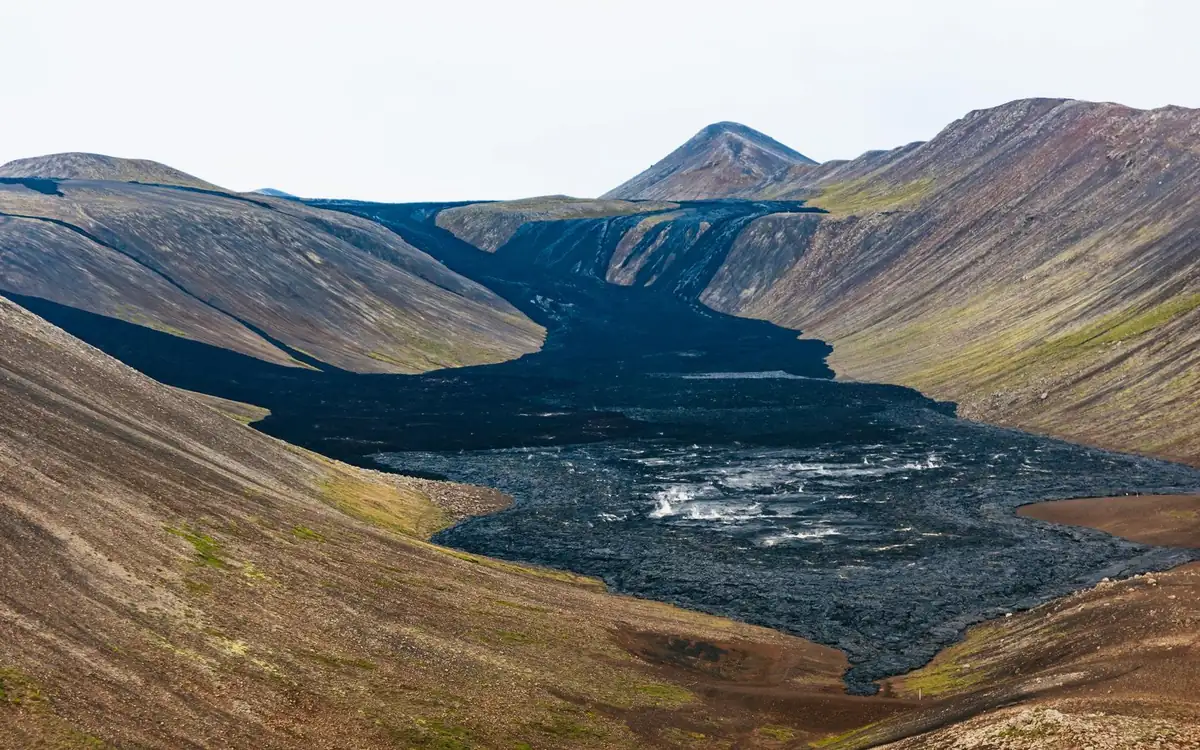 Ein schwarzes Lavafeld, das ein Tal auf der Reykjanes-Halbinsel füllt, aus der Luft gesehen