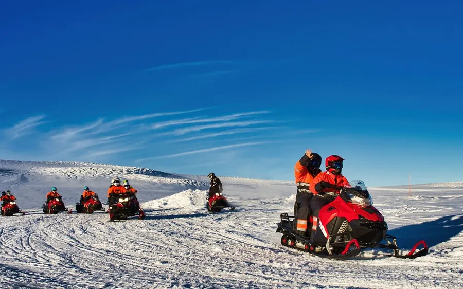 Des motoneiges traversant la surface blanche du glacier Langjokull
