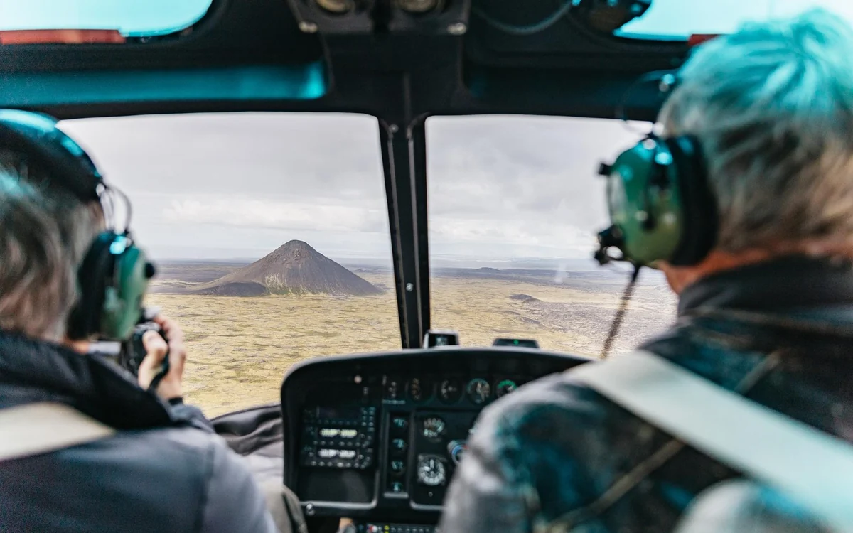 The view forward from a helicopter cockpit over Icelandic terrain
